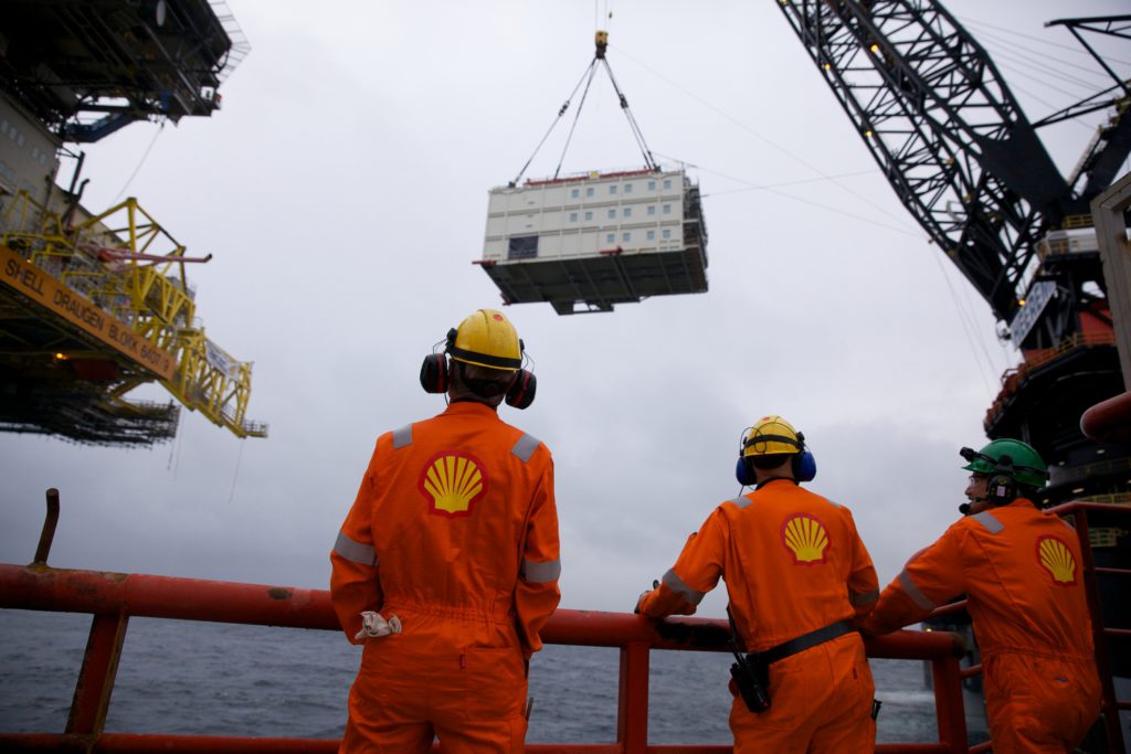 Offshore-arbeidere står spent og overvåker det tunge løftet. Foto:Ukjent